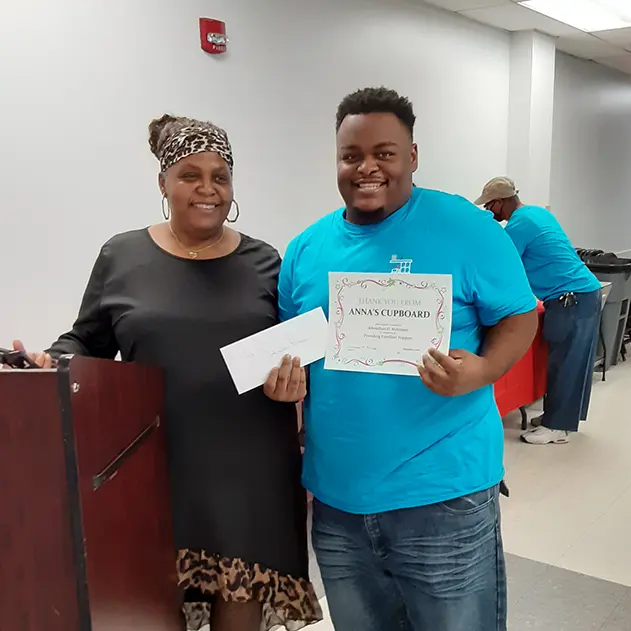 Anna’s Cupboard Founder & CEO, Vanessa Robinson shares a certificate with a client
